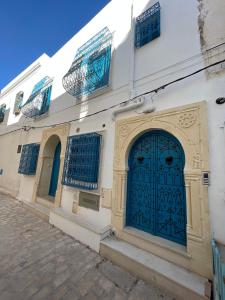 莫纳斯提尔Dar Lilia Monastir的街上有蓝色门的建筑