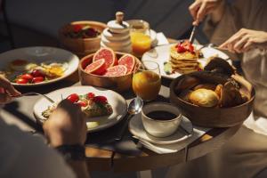 伊罗达伊罗达多姆斯傲途格精选酒店的餐桌上摆放着早餐食品和饮料