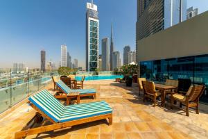 迪拜Exquisite Dubai's Urban Living in the City Centre的一个带桌椅的屋顶露台,享有城市天际线