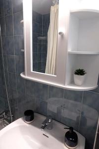 卡莱利亚德帕拉弗鲁赫尔Apartamento con piscina L' Áncora的浴室设有白色水槽和镜子