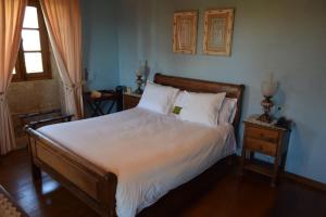 拉科鲁尼亚Pazo do Rio的一间卧室配有一张带白色床单的床和一扇窗户。