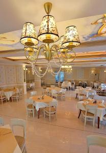 杜普尼察里拉酒店的一间带桌椅和吊灯的用餐室
