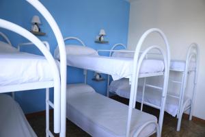 特罗佩阿First Hostel Tropea的蓝色墙壁的客房内的一组双层床