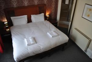 海斯廷斯Town House Rooms的卧室配有白色的床和2个枕头