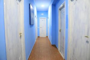 特罗佩阿First Hostel Tropea的走廊上设有蓝色的墙壁和长长的走廊