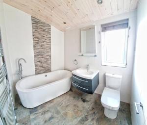 巴洛赫Skyline Lodge Loch Lomond Castle Lodges的带浴缸、卫生间和盥洗盆的浴室