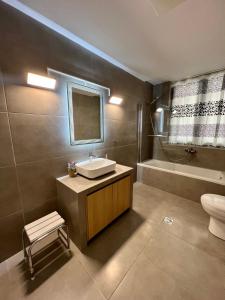 罗德镇Villa 56 Luxury apartments的浴室配有盥洗盆、卫生间和浴缸。
