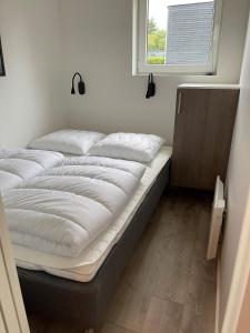 埃斯比约Esbjerg Camping的窗户客房内的一张大床