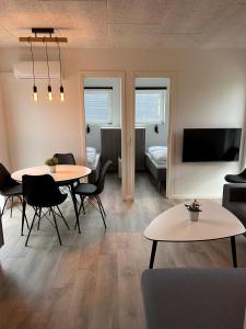 埃斯比约Esbjerg Camping的客厅配有2张桌子、1张沙发和1台电视