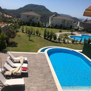 CeditVacation home with private pool, Fethiye, Oludeniz的一座房子旁带躺椅的游泳池