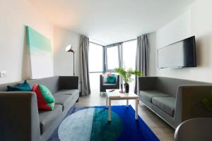 都柏林Chic Apartments and Private Bedrooms at Beckett House near Dublin City Centre的客厅配有两张沙发和一台电视机