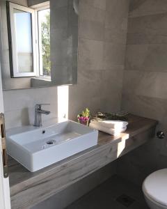 米欧纳伊利亚里度假村的浴室配有白色水槽和卫生间。