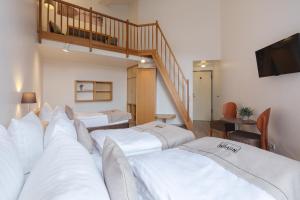 基尔Akademiehotel Kiel的酒店客房设有三张床和楼梯。