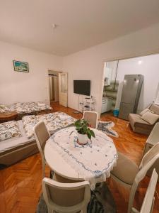 萨拉热窝Nina Apartment的客厅配有两张床和一张桌子及椅子