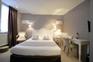 尼奥尔法国酒店的酒店客房设有一张大床和一张书桌。