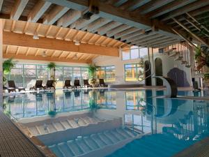 普拉托·阿罗·斯泰尔维奥萨奇牡勒公寓式酒店的大楼内带椅子的大型室内游泳池