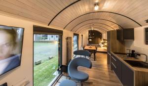 斯塔德特罗恩LokoMotel-Waggon, Luxus Appartment im Eisenbahnwaggon的一间厨房和客厅,位于一栋配有电视的房子内
