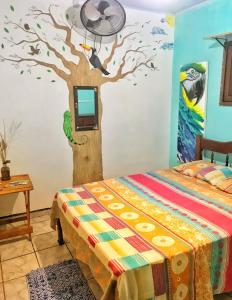 皮帕Hostel Terra Viva的卧室拥有一棵树,墙上配有电视