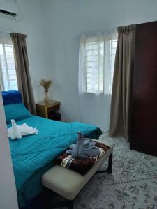 Hutan MelintangHomestay Embah Ros & Embah Lek的一间卧室配有一张带蓝色床单的床和一把椅子