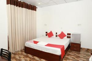 尼甘布Coconut Primitive的一间卧室配有一张带红色枕头的大床