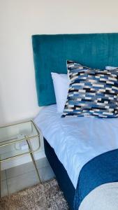 巴利托BALLITO HILLS, 1 bedroom apartment的一张带蓝色床头板和枕头的床