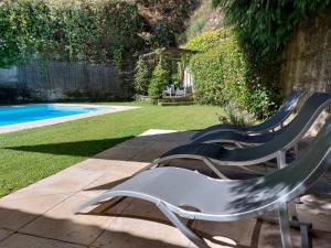 吉尔斯Casa da Terra - Gerês的两把草坪椅坐在游泳池旁