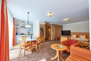 弗隆海姆克劳斯特斯特鲁贝尔酒店的客厅以及带桌子和沙发的厨房。