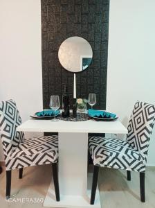 斯雷姆斯卡米特罗维察Apartman SILVER的一张带两把椅子和镜子的白色桌子