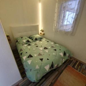 丰罗默奥代洛维亚apt cosy, 4 pers, plein centre ville, parking offert的一间卧室配有一张带绿色棉被的床