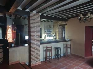 Nava del ReyHotel Restaurante Doña Elvira的餐厅内有砖墙和凳子的酒吧