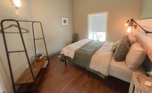 KingsvilleThe Green Heart Inn的一间卧室设有一张床和梯子