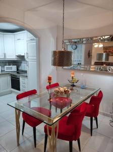 卡亚俄萨尔瓦赫Pendhous Sabina mit Jacuzzi的一间设有玻璃桌和红色椅子的用餐室