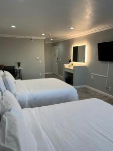 安纳海姆Capri Suites Anaheim的酒店客房设有两张床和一台平面电视。