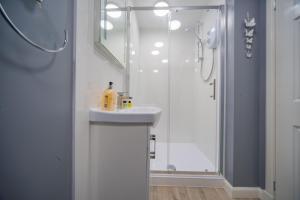 柯科迪Double Ensuite Bedroom near Edinburgh的带淋浴和盥洗盆的白色浴室