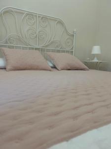 圣米歇尔迪甘泽Casa Pinù的一张带粉红色枕头的床和金属床头板