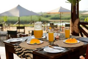 Selous Game ReserveSelous Kulinda Camp的餐桌,带食物和橙汁盘