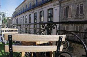 波尔多Galeries - Appartement 2 chambres avec Parking的坐在大楼前的木凳