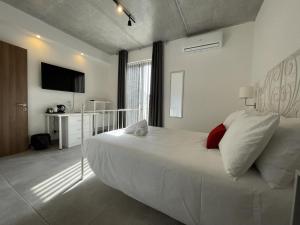 圣朱利安斯Casa Leon Malta的卧室配有白色的床和红色枕头