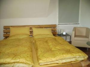 梅伦昂比恩蒂度假屋的一间卧室配有一张带黄床单和椅子的床