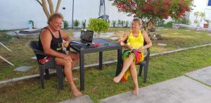 阿杜环礁Clove Beach的两名妇女坐在一张桌子上,手提电脑