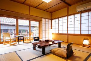京都桑加旅馆的客厅配有桌椅和窗户。