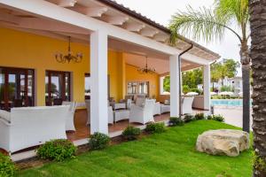 圣玛丽亚纳瓦雷Marina Torre Navarrese Resort的一个带白色椅子和游泳池的庭院