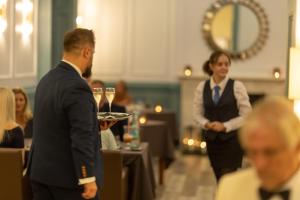 文特诺皇家酒店的一个人在与人同住的房间里拿着酒杯托盘