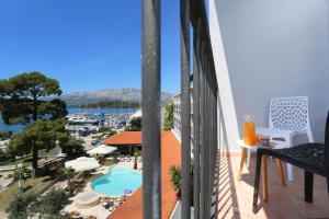 鲁巴达Hotel Lumbarda的阳台享有游泳池和码头的景致。