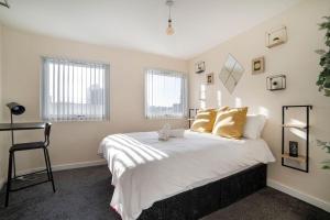 莱斯特Leicester City Center - TBH的一间卧室配有带白色床单和金色枕头的床。