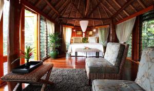 萨武萨武Namale All Inclusive Resort & Spa的卧室配有一张床和一张桌子及椅子