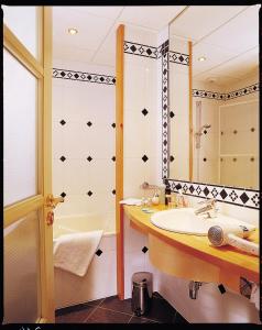 比奇乐斯特拉斯堡酒店及餐厅的一间带水槽、浴缸和镜子的浴室