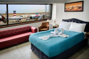 特拉布宗Elite Holiday Hotel的一间卧室配有一张床、一张沙发和一个窗口