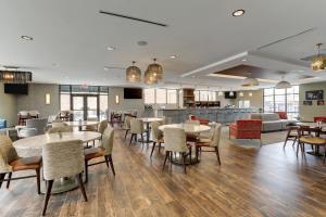 CherawSpringHill Suites by Marriott Cheraw的一间带桌椅的餐厅和一间酒吧
