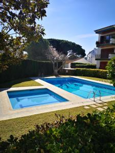 卡莱利亚德帕拉弗鲁赫尔Apartamento con piscina L' Áncora的一座游泳池,位于一座建筑旁的院子内